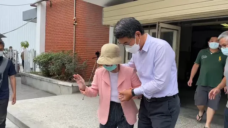 劉建國攙扶母親走出投票所。魏嘉良攝