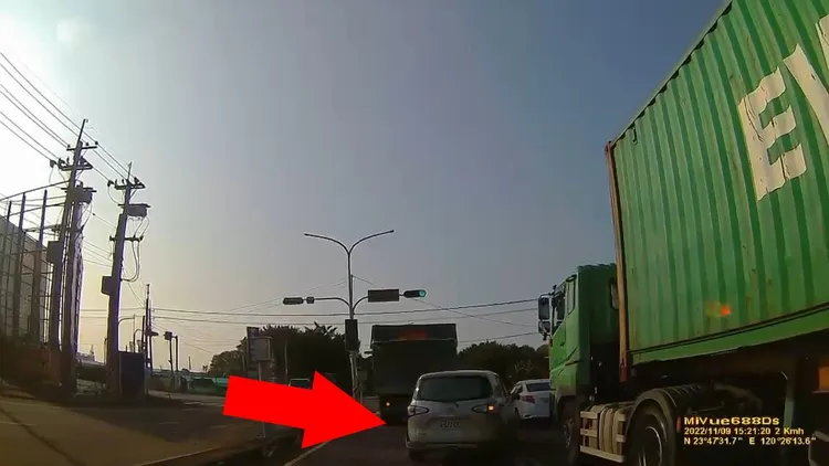 前方貨車準備左轉，銀色休旅車亮起右方向燈，即向右硬切鑽縫。攝自《記者爆料網》