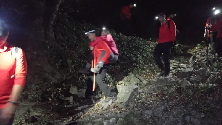 搜救人員連夜將傷者揹下山。李陳信得攝
