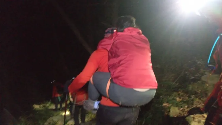 搜救人員輪流用揹負方式將傷者揹負下山。李陳信得攝