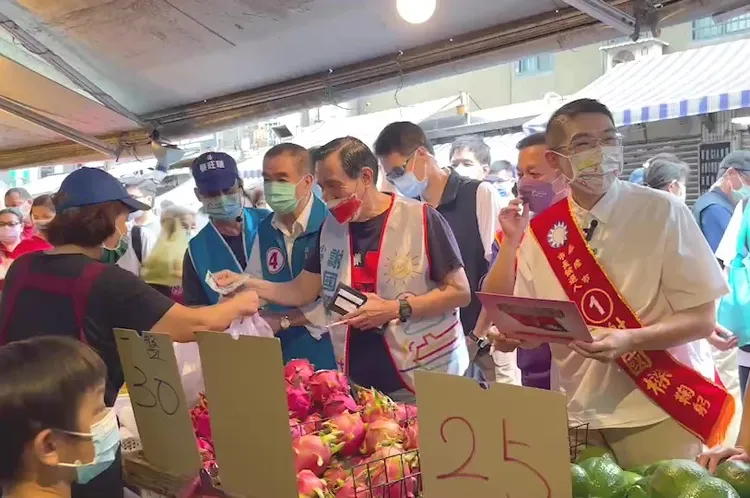 馬英九除了幫謝國樑拜票，也向市場攤商購物。翻攝畫面