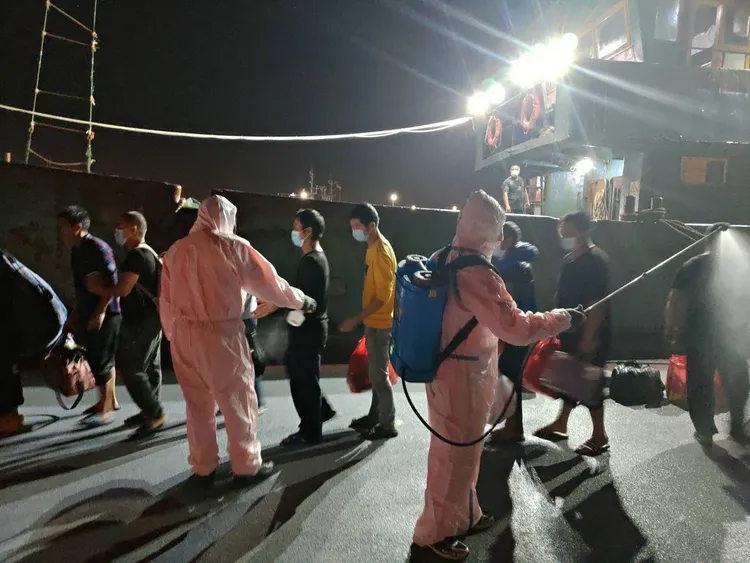 海巡隊員針對被押回的船員消毒。台中海巡隊提供