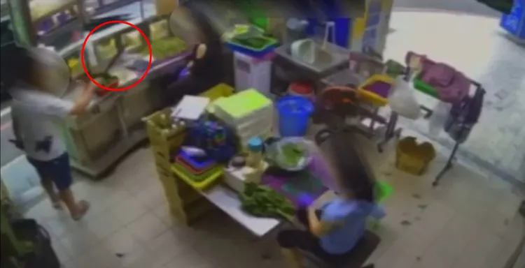 李男拿開山刀（紅圈處），對女店員嗆：「會再回來算帳。」讀者提供