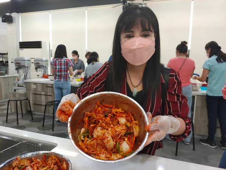 越南新住民阿雁展示自己完成的泡菜成品。移民署提供