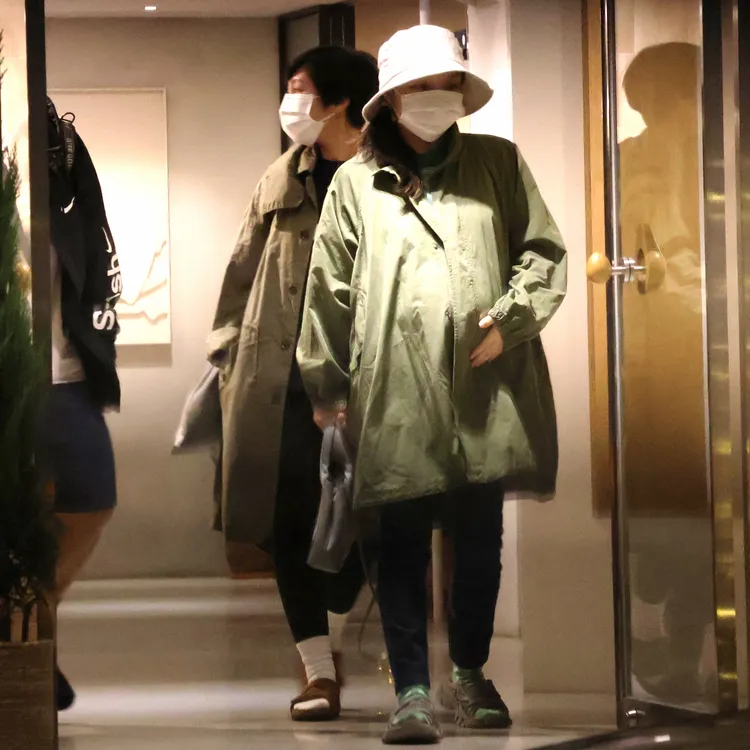 金曲歌后徐佳瑩（右）穿上外套，和工作人員離開咖啡廳。特勤中心攝