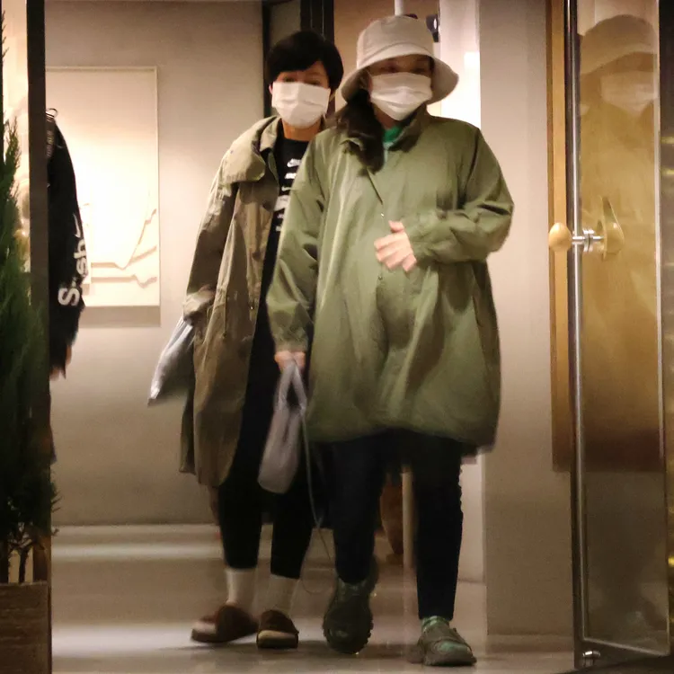 金曲歌后徐佳瑩（右）抱著肚子跟工作人員一起離開。特勤中心攝