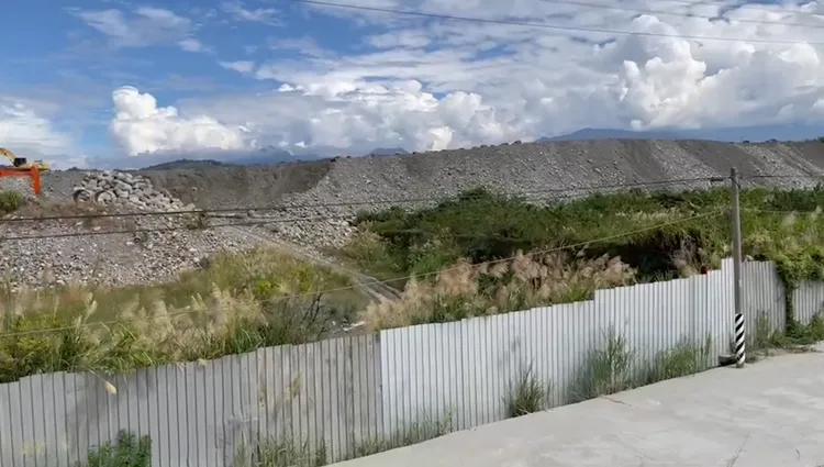 現場堆積砂石估計有5層樓高。讀者提供