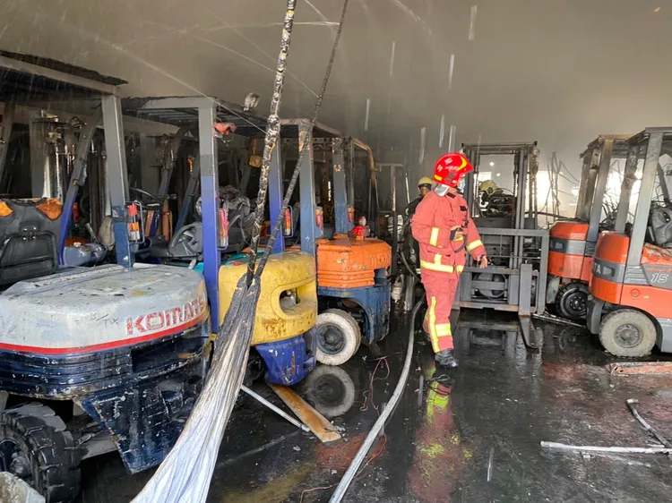 現場存放大批堆高機，警消灌救。讀者提供