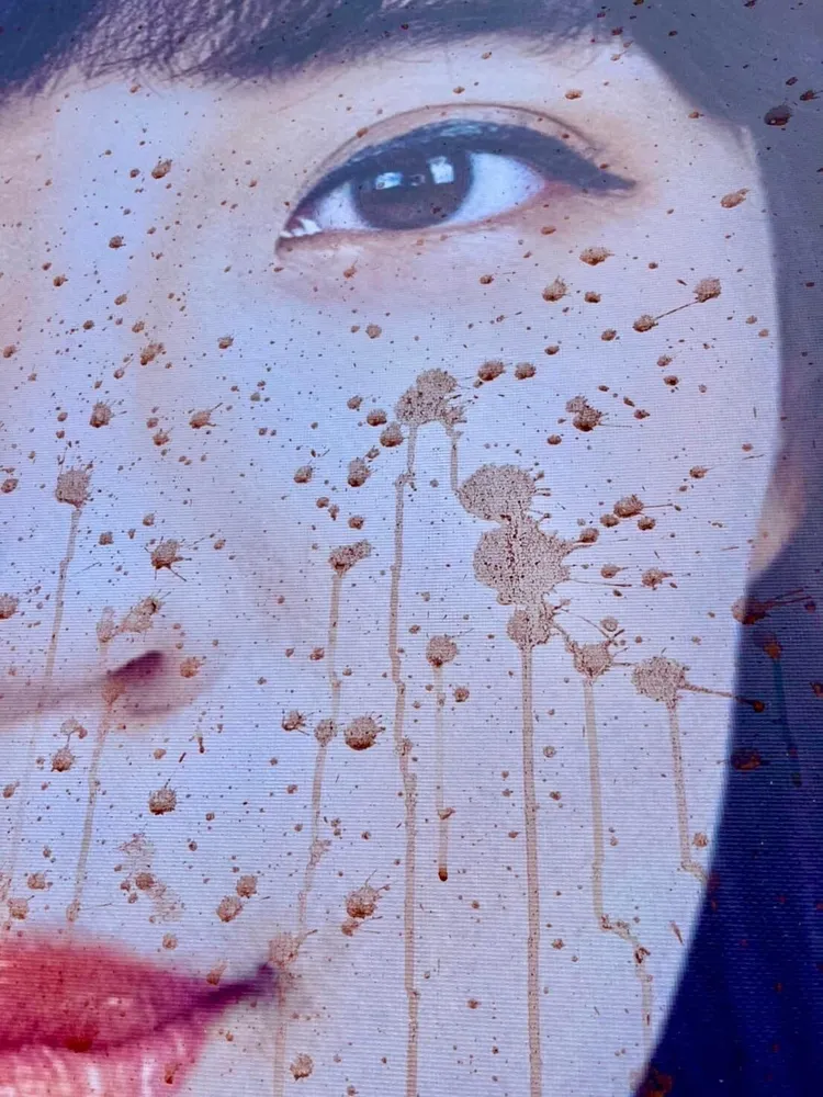 看板上黃捷的臉部被檳榔汁汙損。讀者提供