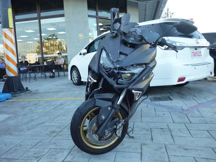 22歲李姓騎士綠燈時通過路口撞上千萬賓利跑車，摔車後無恙但機車毀損。讀者提供