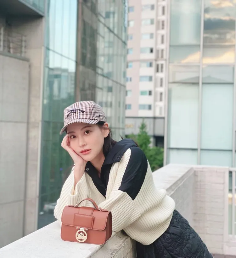 韓星吳漣序身穿LONGCHAMP白色毛衣套頭衫和黑色尼龍短裙及奔馬Logo鴨舌帽造型，配搭Box-Trot迷你包擺拍，隨性展現清新優雅風采。翻攝ohvely22 IG