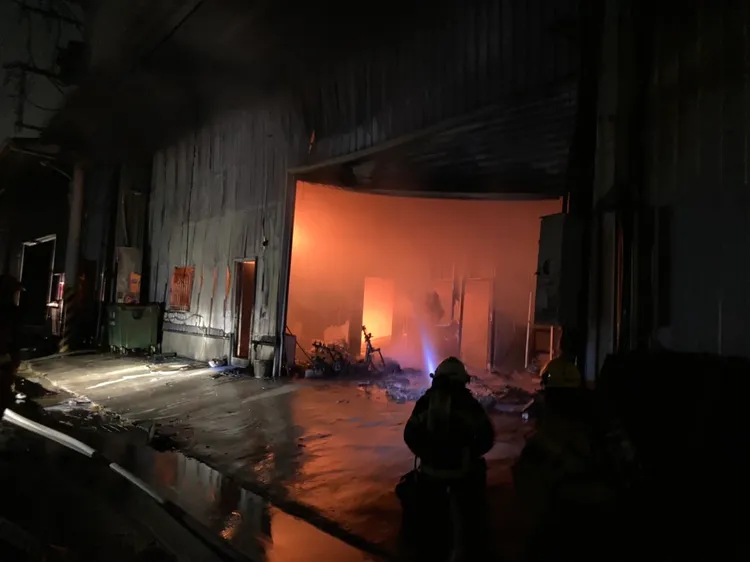 消防人員拉水線搶救。讀者提供