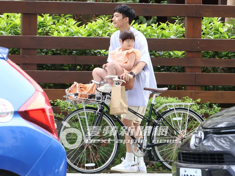 吳念軒牽著腳踏車接女童下課，小女孩不時回頭望。特勤中心攝