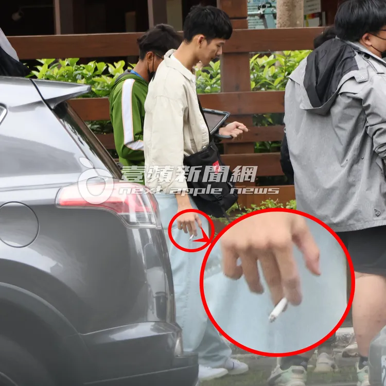 吳念軒趁著休息空檔，拿著香菸在人行道上吞雲吐霧。特勤中心攝