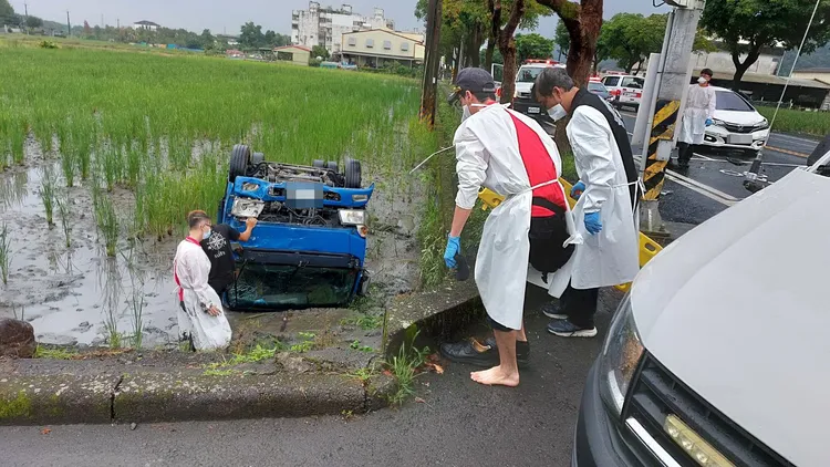 小貨車路口撞上救護車後，失控翻落田中四輪朝天，救護車上人員立即下車協助救援。讀者提供