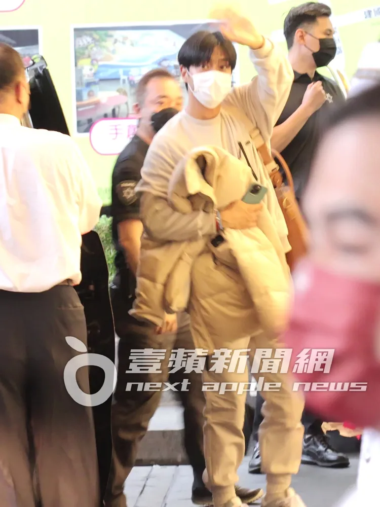 韓國天團SJ的成員始源（中）率先抵台，手拿iPhone返回下榻的晶華酒店，回頭親切跟粉絲揮手打招呼。特勤中心攝