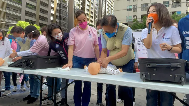 張善政為嬰兒著裝。張沛森攝