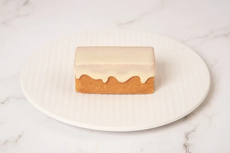 雪白色「法芙娜柚香風味調溫可可脂」醬淋在經典奶油酥皮最上層。業者提供