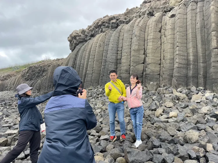 遊客到池西岩瀑前合影，直接體驗到改善後不再拐腳。澎管處提供