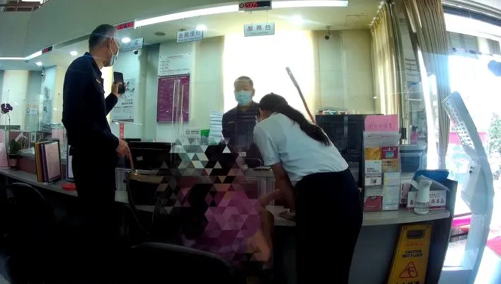 警員與行員在櫃檯前力勸林女。保七提供