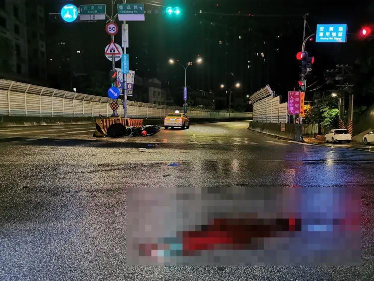 機車騎士一摔車撞分隔島，事故現場殘留大片血跡。陸運鋒攝