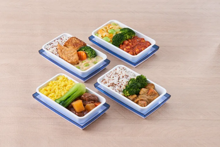 華航空中旅人純淨蔬食經濟艙餐點，經濟艙四種隨機主菜如紅醬植物肉貝殼麵、白醬植物排藜麥飯、咖哩杏鮑菇燴飯及紅燒植物肉薑黃飯。有別於以往的東方素食餐點。華航提供