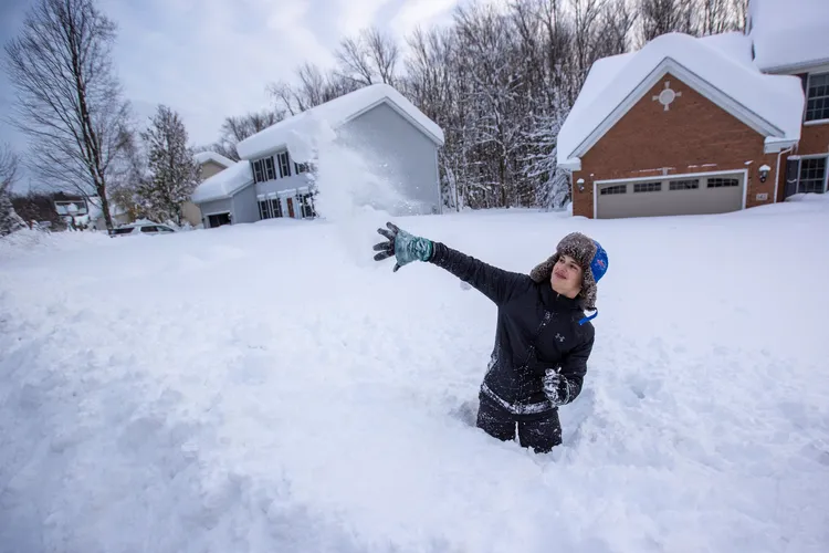 一名少女在雪地裡朝玩伴扔雪球。路透社