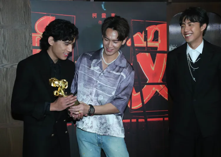 柯震東（中）和蔡凡熙（右）盯著朱軒洋的獎座。鄭孟晃攝