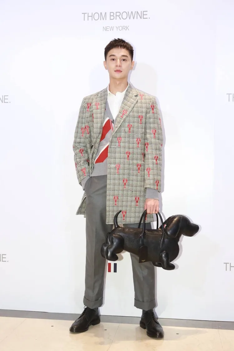 男星張軒睿以THOM BROWNE經典灰色主調的龍蝦刺繡圖案千鳥格紋大衣搭配9分西裝褲裝扮逛店，自評造型「沈穩內斂又活潑」。朱世閎攝