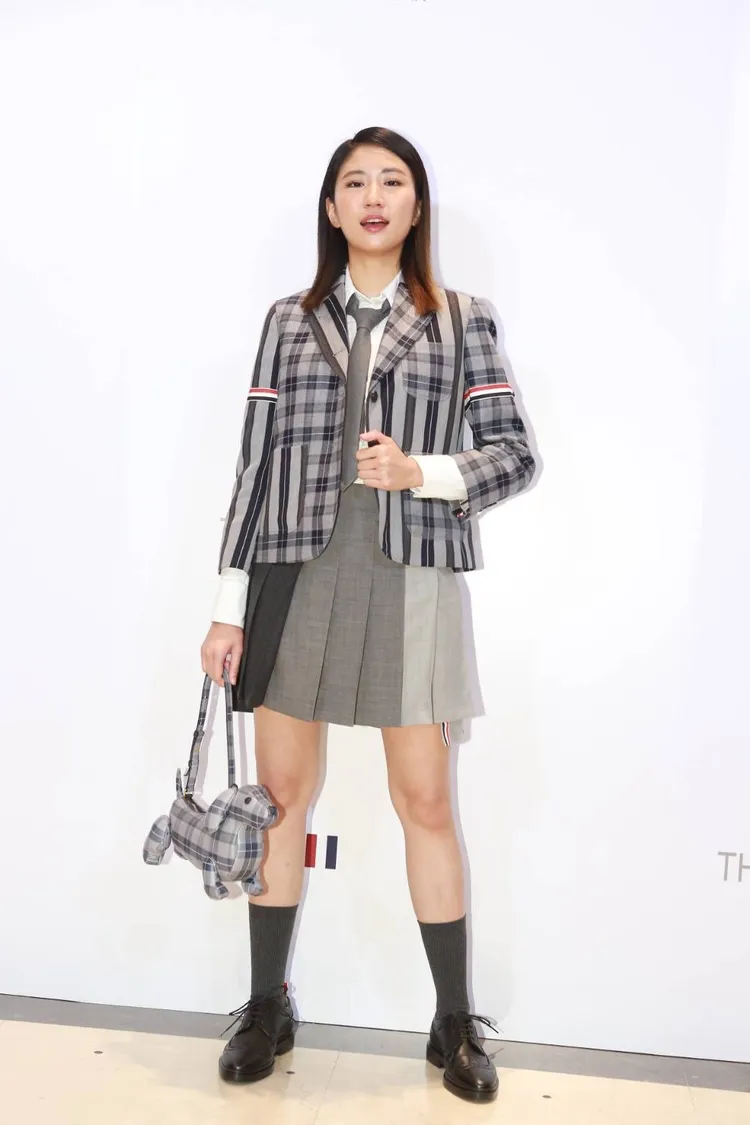歌手9m88穿THOM BROWNE蘇格蘭格紋西裝外套搭百褶裙的學院制服風格造型，俏麗變回高中生模樣。朱世閎攝