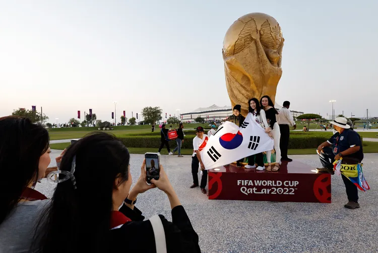 親赴卡達觀戰的南韓球迷20日在球場外留影。路透社