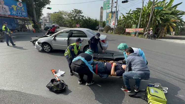 警消與民眾合力將壯碩的騎士抬上擔架。侯昌騰攝