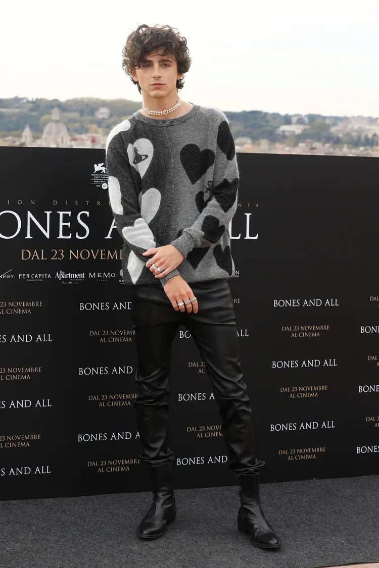 甜茶上半身穿著Vivienne Westwood灰色有愛心與品牌土星logo圖案的毛衣，脖子戴著精緻骨頭裝飾珍珠頸鏈，下半身穿皮褲搭皮靴。達志