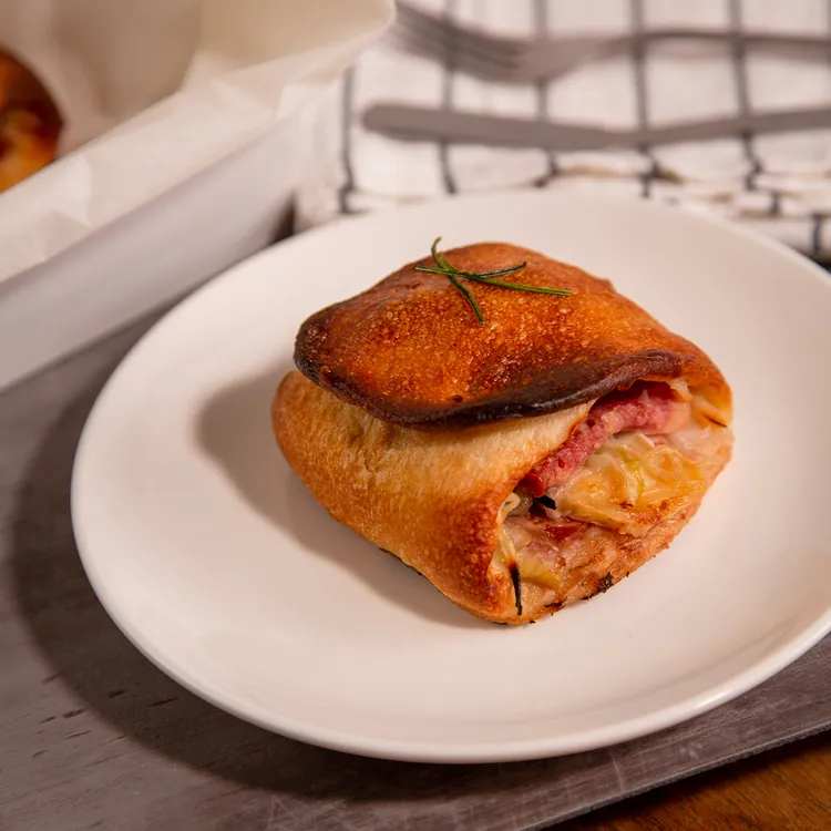 台北車站前的老牌名店優仕紳，把料理搬進麵包，利用康門貝爾乾酪完美協調多樣副食材，提高整體協調性。