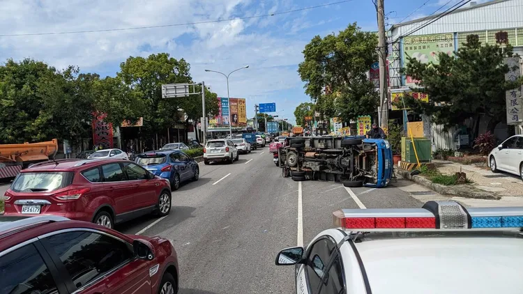 貨車翻覆佔據機慢車道，造成後方車流回堵。讀者提供