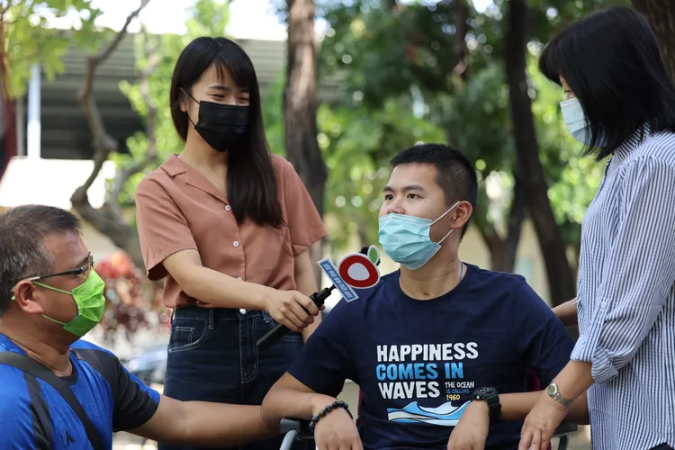 妹妹幫忙拿麥克風訪問秦良丰頗有當記者的氣勢。侯昌騰攝