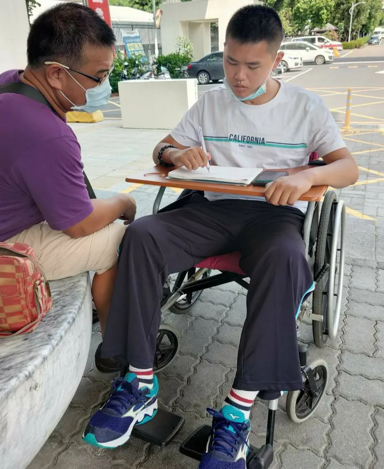 秦爸爸陪伴秦良丰寫語言治療的功課。秦爸爸提供