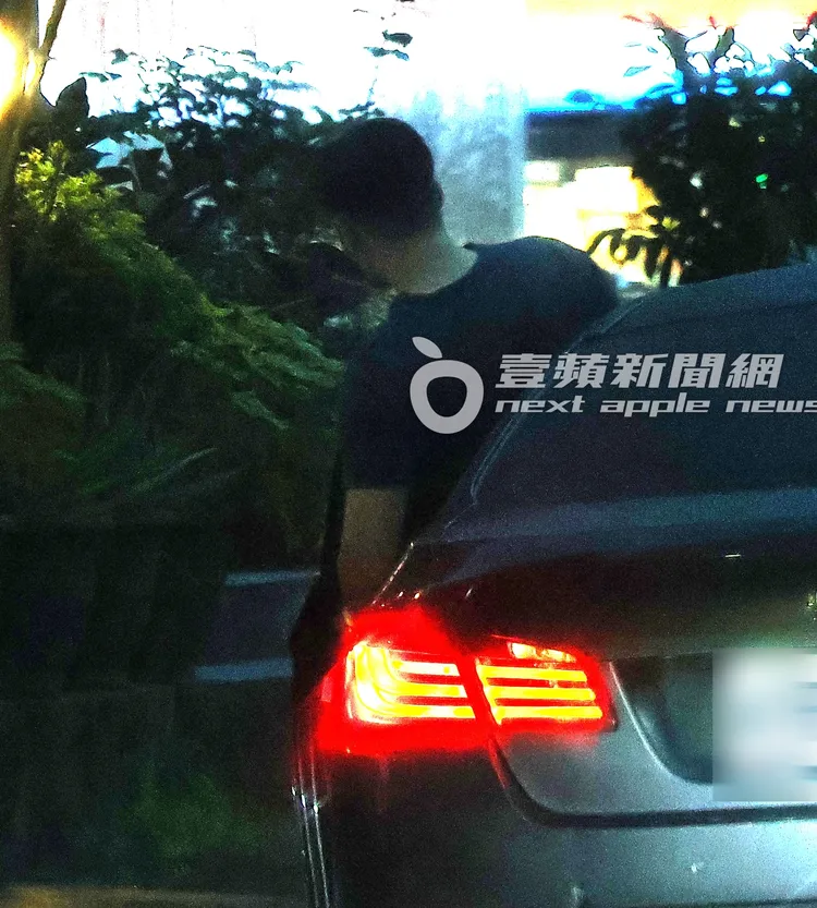 徐新洋坐進BMW轎車後，待在車內滑手機。特勤中心攝