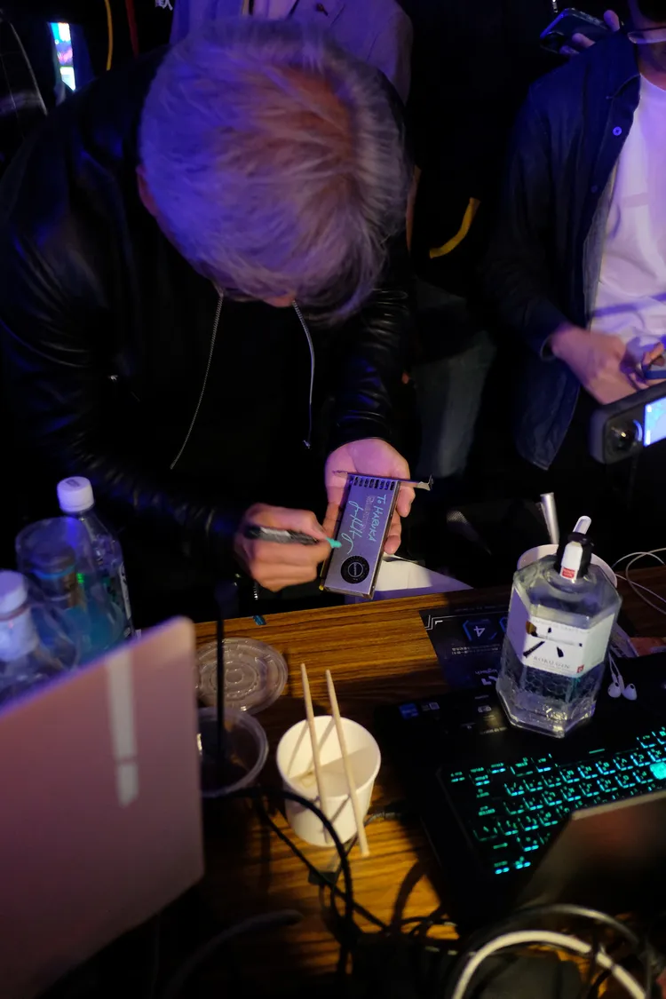 黃仁勳展現親民態度，親簽玩家的 NVIDIA 顯卡彩盒、周邊紀念品等。業者提供