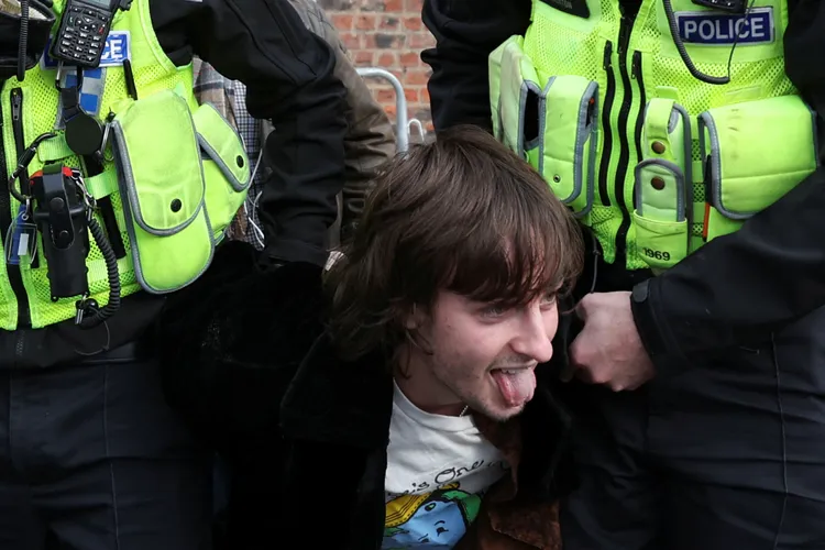 這名男子涉嫌當場向英王砸雞蛋遭警方逮捕，他就逮時還吐舌頭。路透社
