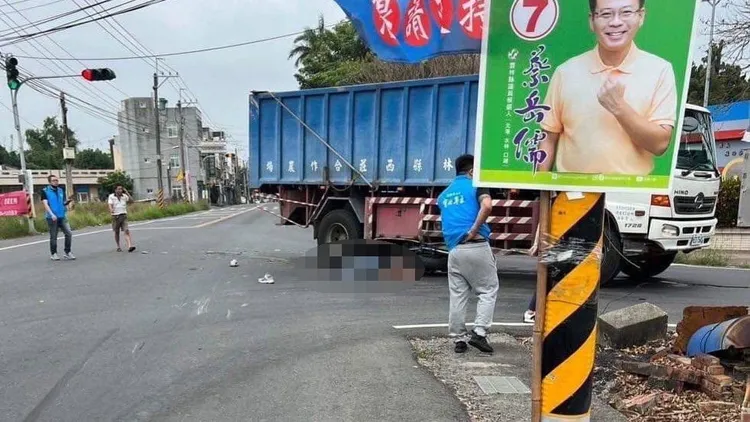 車禍發生後，附近民眾趕忙上前查看，重機騎士人車仰躺貨車右側車底。取自《記者爆料網》