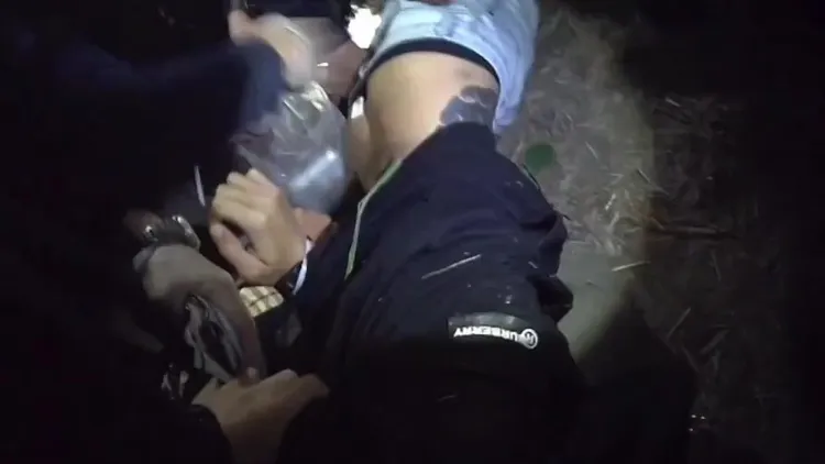 眾警順著散落鈔票，在草叢內揪出翁男，壓制逮捕時身上還掉落多張鈔票。民眾提供