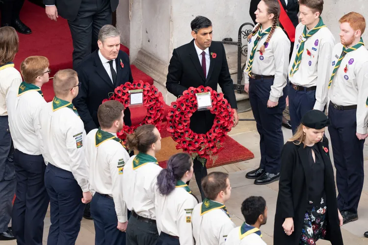 英國工黨黨魁施凱爾（Keir Starmer，左）、首相蘇納克（右）13日手持致敬花環出席國殤日儀式。路透社