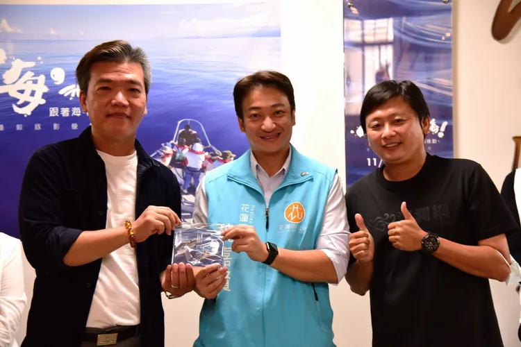 攝影師楊均濰（右一）跟著賞鯨船出海拍下果凍海美景，花蓮市長魏嘉賢（中）促成展覽。市公所提供