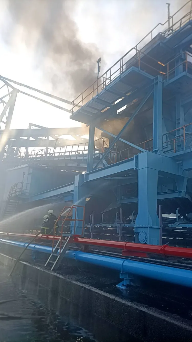 中火煤炭轉運塔不斷冒出濃煙，消防人員佈署水線灌救。台中港消防隊提供