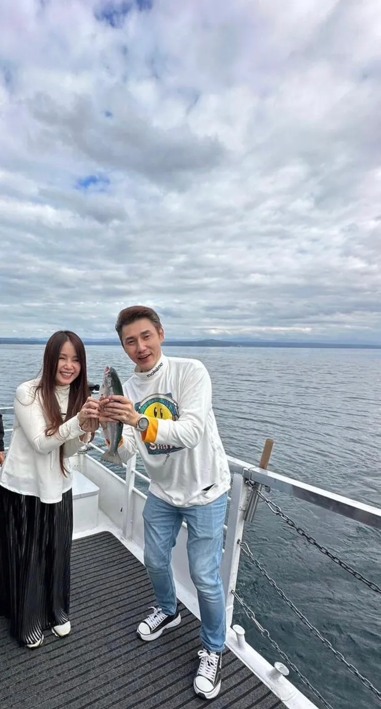 包偉銘（右）夫婦在陶泊湖坐遊船體驗釣魚活動。經紀人陳家倫提供