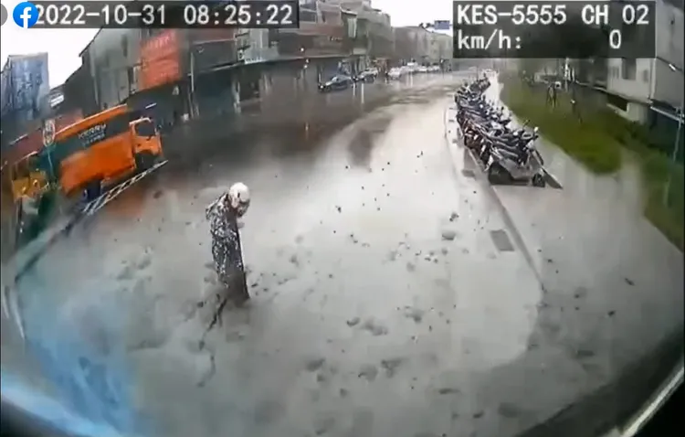 闖紅燈的行人被砂石車後方的泥水淹沒雙腳。翻攝爆料公社