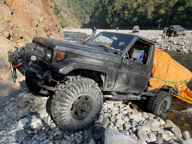 拼裝吉普車逃逸過程卡在溪床石礫堆，動彈不得，其中一名山老鼠趁隙逃逸。警方提供