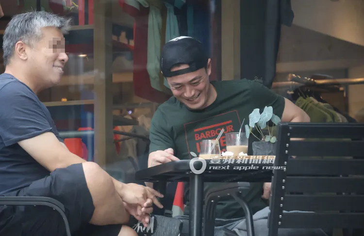 霍建華（右）將棒球帽反戴，邊滑手機跟友人聊天笑開懷。特勤中心攝