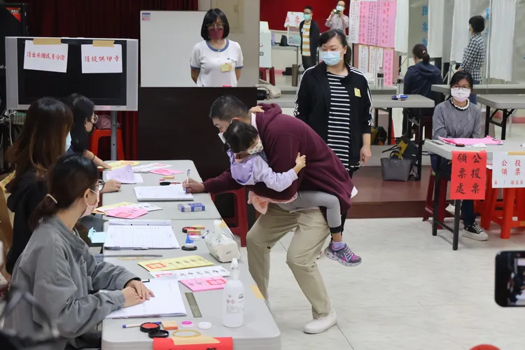 謝國樑一路抱著女兒完成投票程序。戴之聖攝